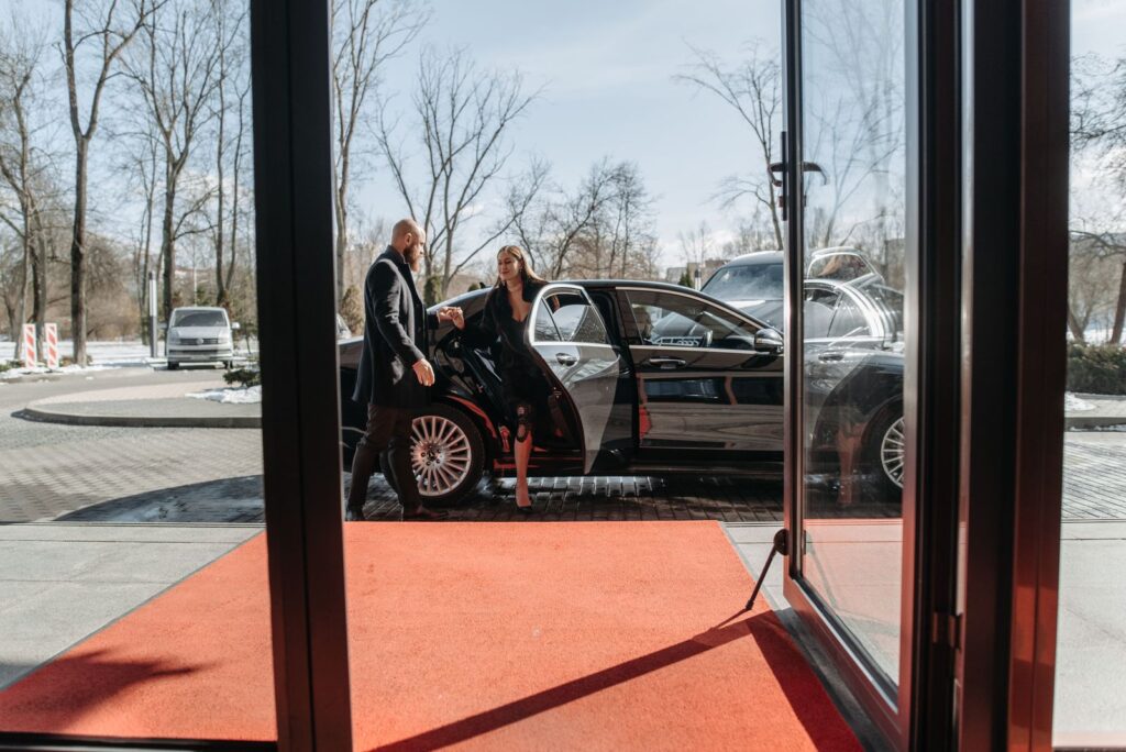 Avante chauffeur helping a guest out of a black car for a LUZIA night in Vancouver