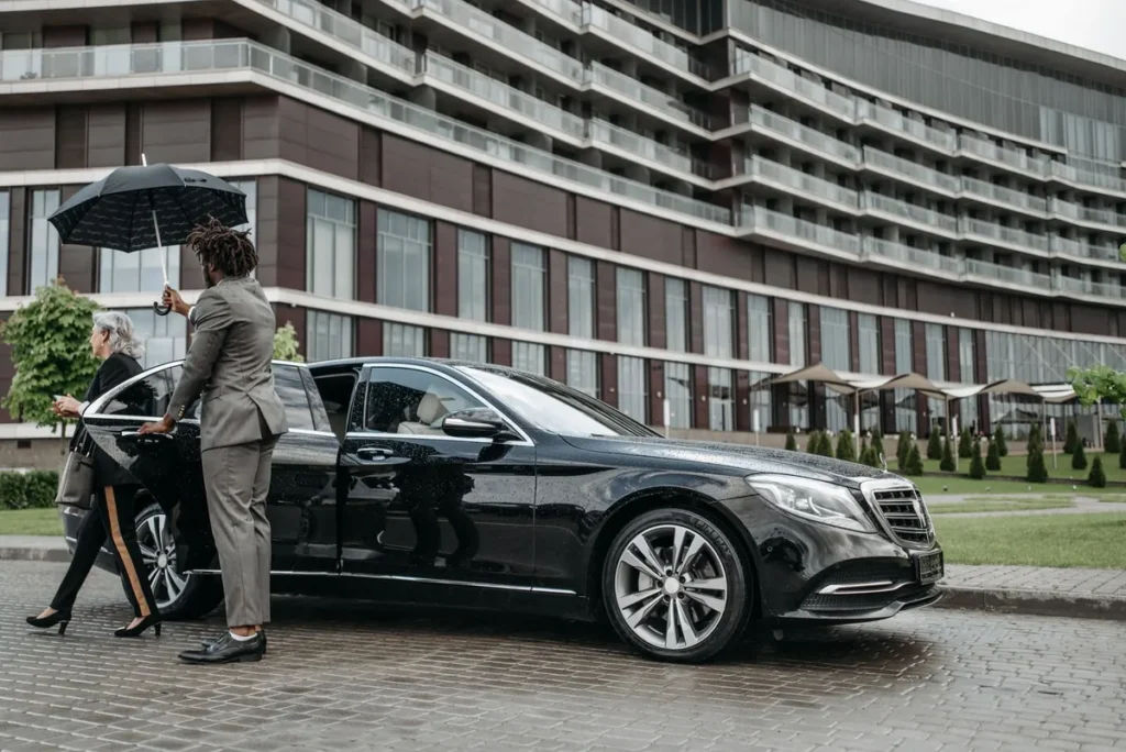 Avante chauffeur helping guests into a black sedan for Cornucopia Whistler evenings